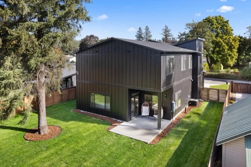 Aerial view of dark-sided home with large backyard